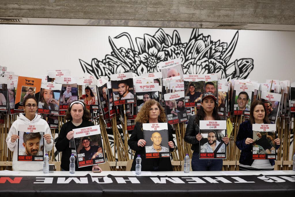 שורדות השבי בהצהרה, עם תמונות יקיריהן (צילום: REUTERS/Stoyan Nenov) הצהרה של שורדות שבי חמאס