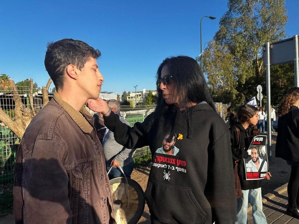 צנגאוקר עם אחד התלמידים שהפגינו בצומת הכפר הירוק, לציון יום הולדתו השני של מתן צנגאוקר בשבי (צילום: עודד אנגל) עינב צנגאוקר בהפגנה בצומת הכפר הירוק לציון יום הולדתו של מתן בשבי