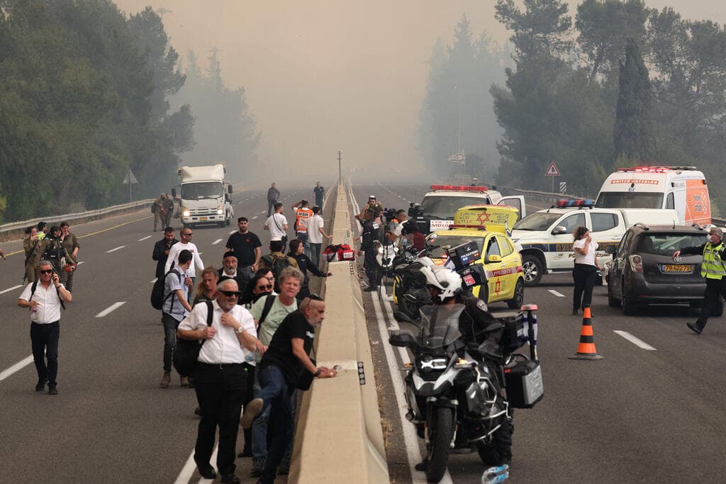 צילום: Ahmad GHARABLI / AFP האש מתקרבת לרכבים בכביש 1