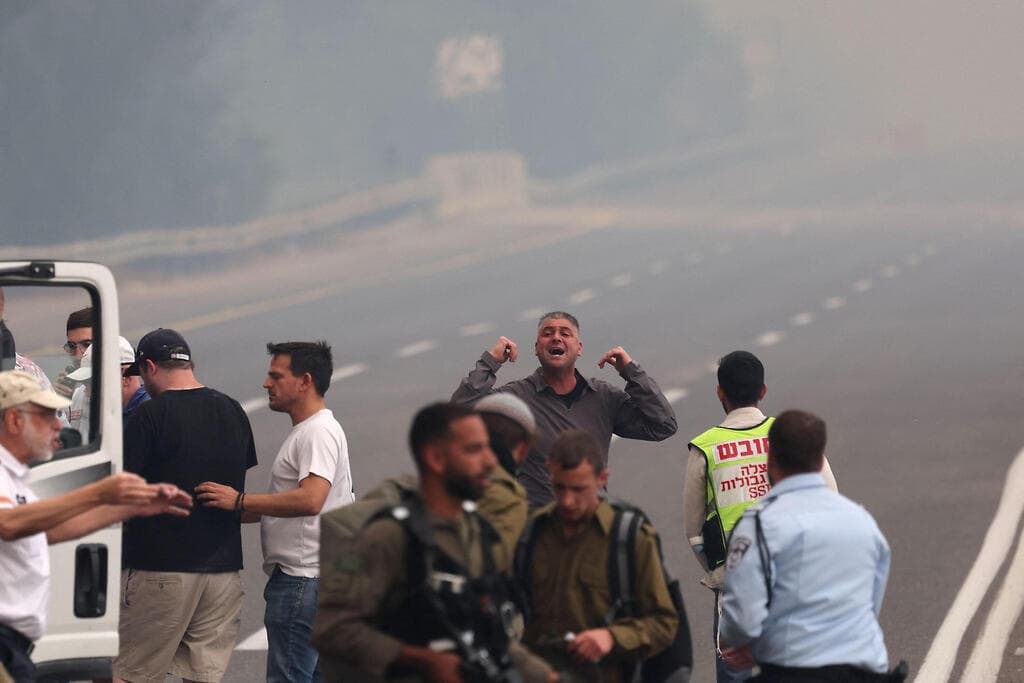 צילום: Ahmad GHARABLI / AFP האש מתקרבת לרכבים בכביש 1