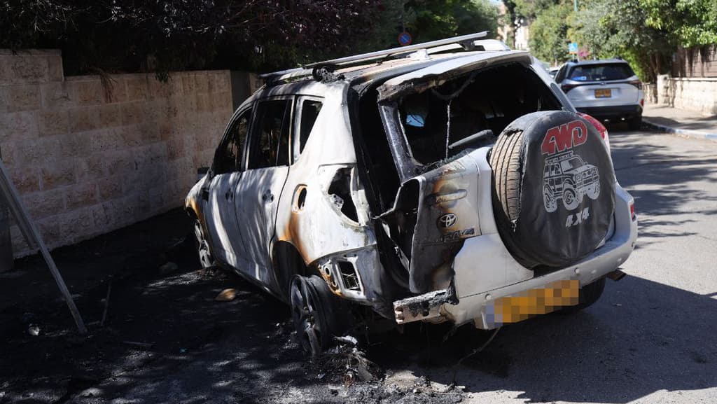 הרכב שנשרף כתוצאה מהבערת הפחים (צילום: אלכס קולומויסקי) רכב נשרף ברחוב עזה בירושלים כתוצאה מפעילות מחאה באזור למען החטופים