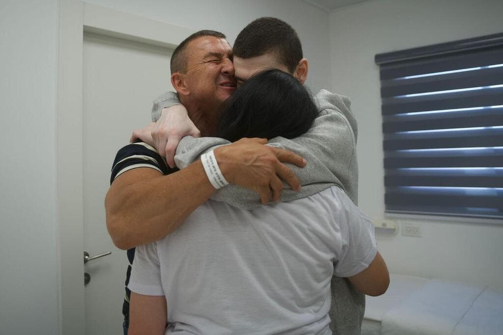 מקסים הרקין מתחבק עם הוריו (צילום: דובר צה"ל) מקסים הרקין במפגש עם משפחתו