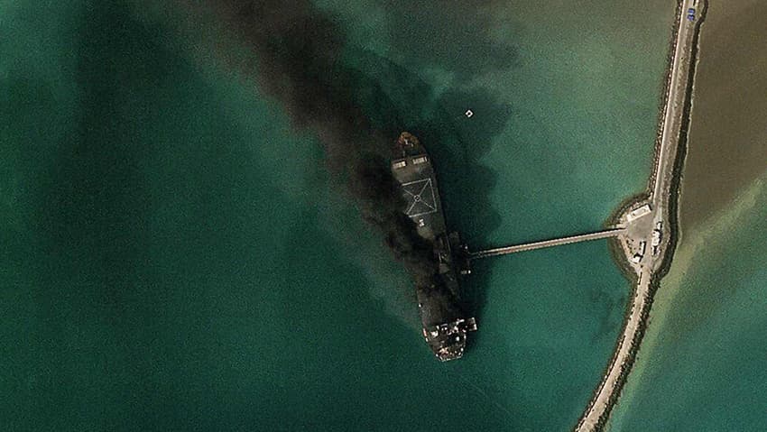 ספינה עולה באש בנמל בנדר עבאס (צילום: AFP PHOTO / © 2026 PLANET LABS PBC) נמל בנדר עבאס