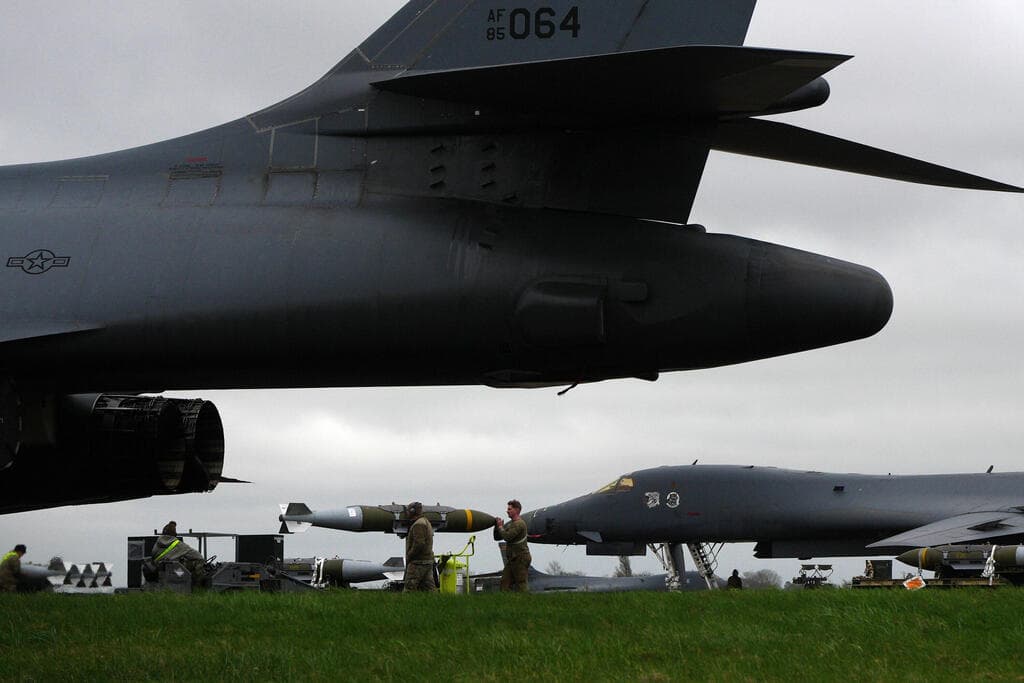 חייל אמריקני מכין פצצה חודרת בונקרים  JDAM לצד מפציצים מפציץ B-1B של חיל האוויר של ארה"ב לקראת הפצצות ב איראן ב בסיס אווירי ב פיירפורד בריטניה