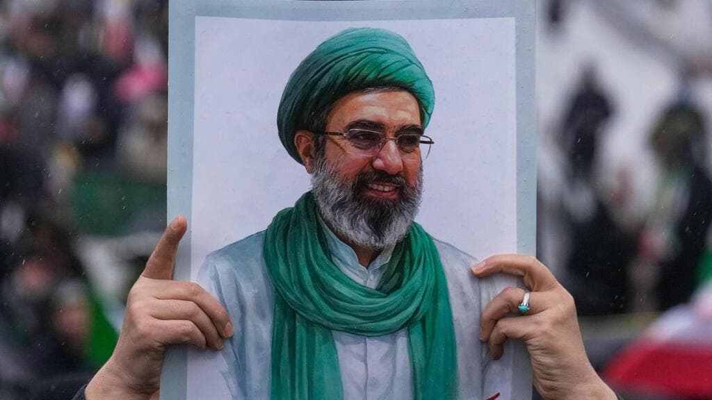 תומכי המשטר מניפים תמונות של מוג'תבא חמינאי (צילום: AP Photo/Vahid Salemi) תומכי המשטר ב איראן מניפים תמונות של המנהיג העליון החדש מוג'תבא חמינאי