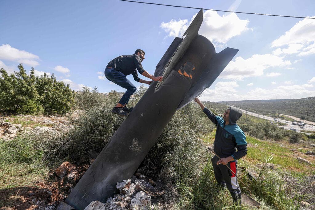 שרידים של טיל איראני (צילום: JAAFAR ASHTIYEH / AFP) פלסטיני על שרידי טיל איראני