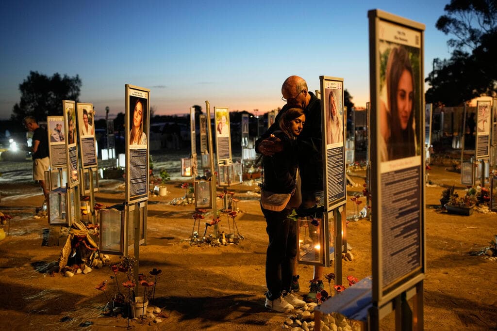 צילום: AP Photo/Ohad Zwigenberg בני ומגי סולומון ליד תמונה של בתם הילי שנרצחה במסיבת הנובה