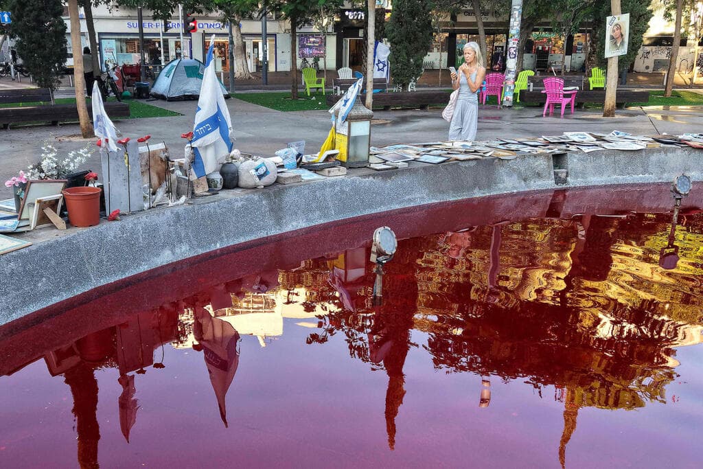 צילום: Jack GUEZ / AFP מזרקת דמים לציון שלוש שנים לטבח