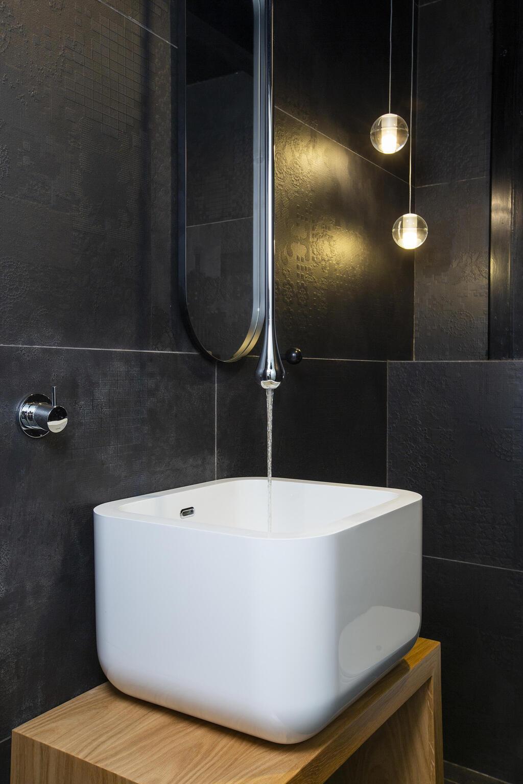 ברז תלוי מהתקרה בשירותי האורחים הכהים (צילום: עידן גור) דירת דופלקס-גן בתל אביב, עיצוב: מיטל צימבר