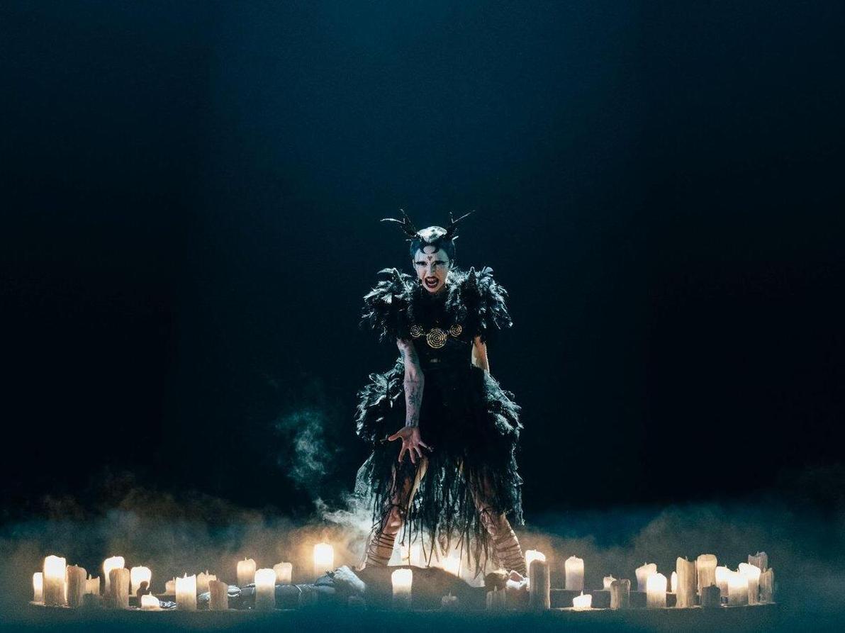 פלטת שיניים מוזהבת, זוג קרניים, איפור אפל ושמלה שחורה מקושטת נוצות. במבי ת'אג מאירלנד (צילום: Sarah Louise Bennett/EBU) במבי ת'אג מאירלנד באירוויזיון, 2024