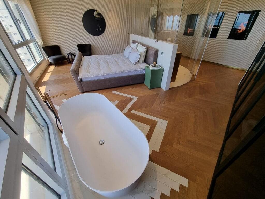 חדר שינה עם מקלחת שקופה באמצע. עיצוב: צביה קזיוף