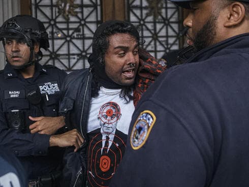 מפגין לובש את החולצה של Comrade Workwear בהפגנה נגד ישראל בניו יורק, מאי 2024