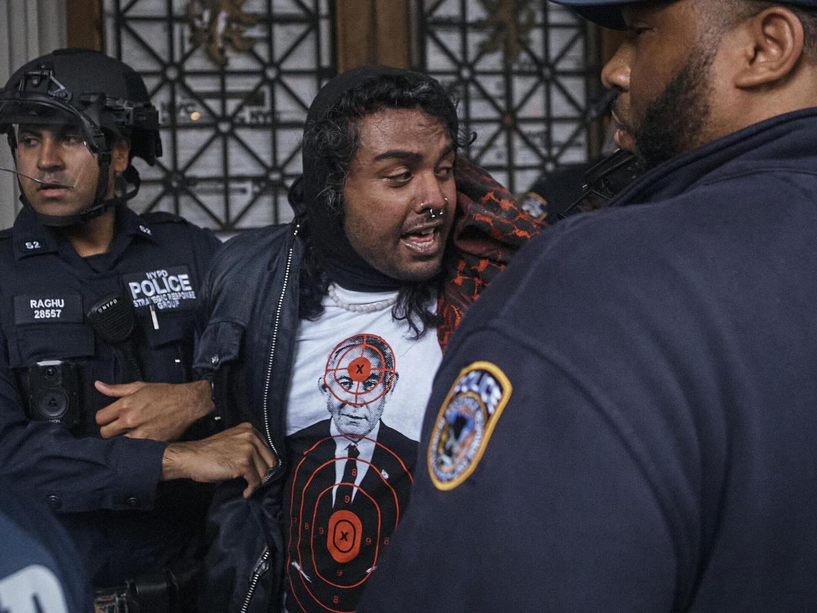 מפגין לובש את החולצה של Comrade Workwear בהפגנה נגד ישראל בניו יורק, מאי 2024