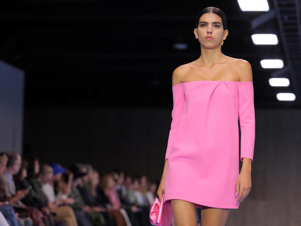 על המסלול של הררה צעדה גם הישראלית סאן מזרחי, בשמלה בצבע בזוקה חושפת כתפיים ותיק תואם (צילום: REUTERS/Andrew Kelly) סאן מזרחי בתצוגת אביב-קיץ 2025 של קרולינה הררה