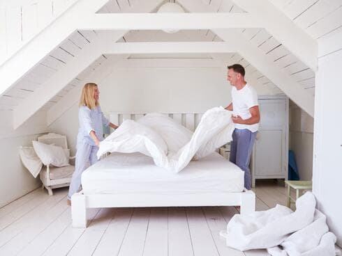 זוג מסדר את המיטה