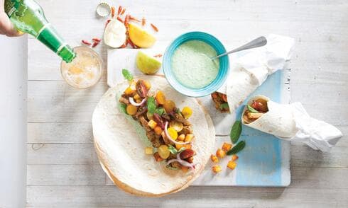 בתוך הטורטייה: שווארמה, תפוחי אדמה, סלט עגבניות וטחינה ירוקה 