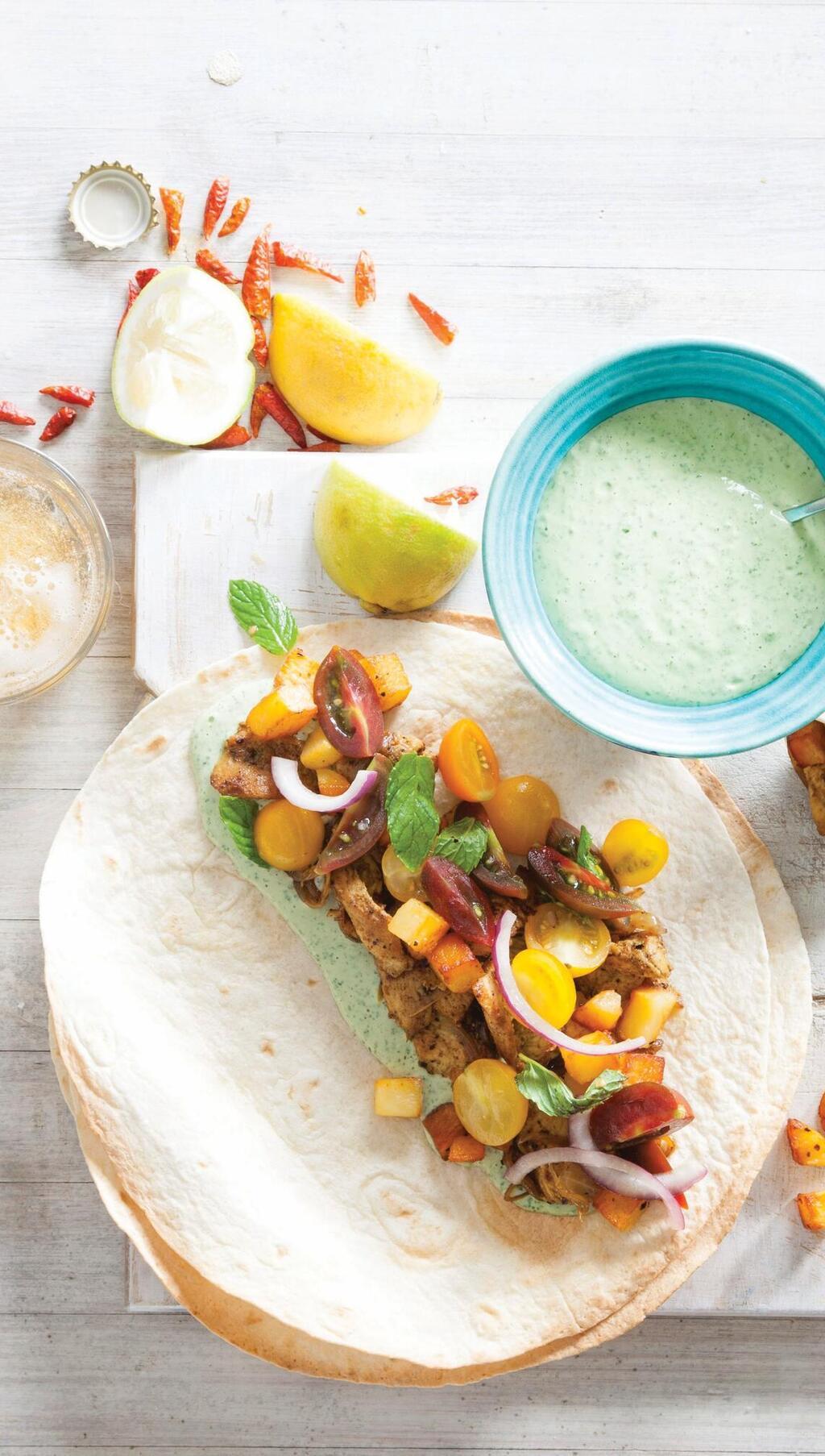 בתוך הטורטייה: שווארמה, תפוחי אדמה, סלט עגבניות וטחינה ירוקה 