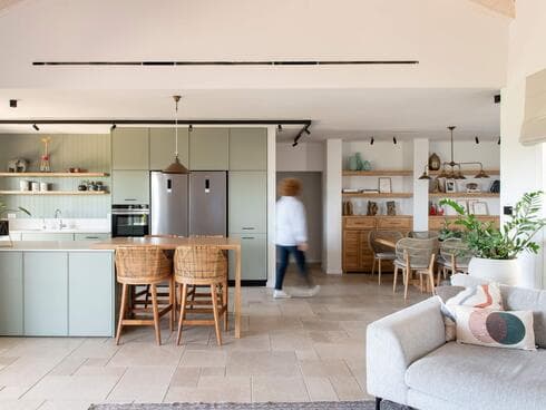 מטבח עם ארונות עד התקרה ותאורה חמימה. עיצוב: פנינה רימון