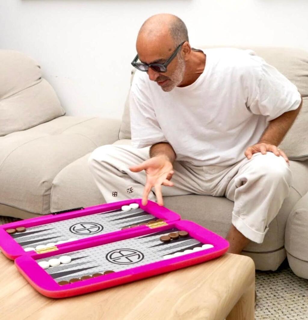 אריק בן שמחון משחק שש בש בעיצובו בחנות שלו