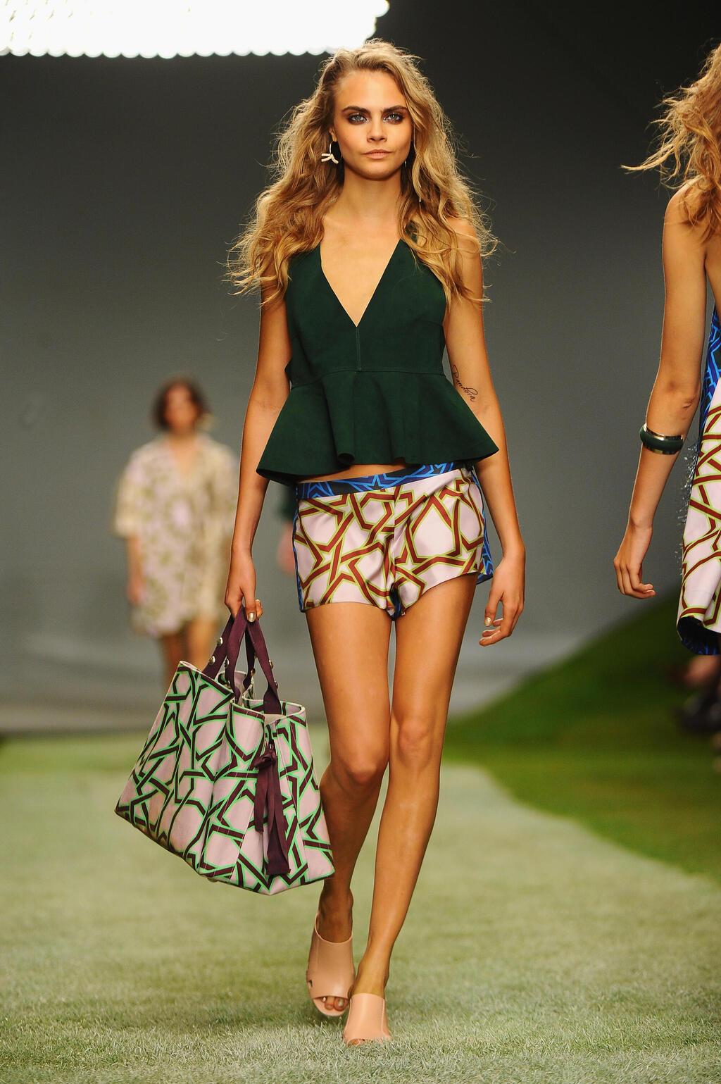 קארה דלווין מדגמנת בתצוגת אביב-קיץ 2014 של טופשופ יוניק בשבוע האופנה בלונדון