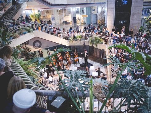 מופע בבניין כלל, הקהל עומד לאורך הספירלה המאפיינת את הפנים