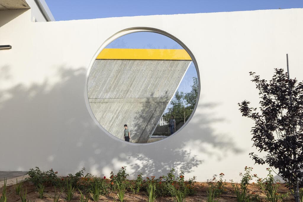 קיר בטון חשוף ומצולע, כאזכור למערכת הטיפוס המתגלה בפנים (צילום: נמרוד לוי) קיר טיפוס אולימפי במודיעין