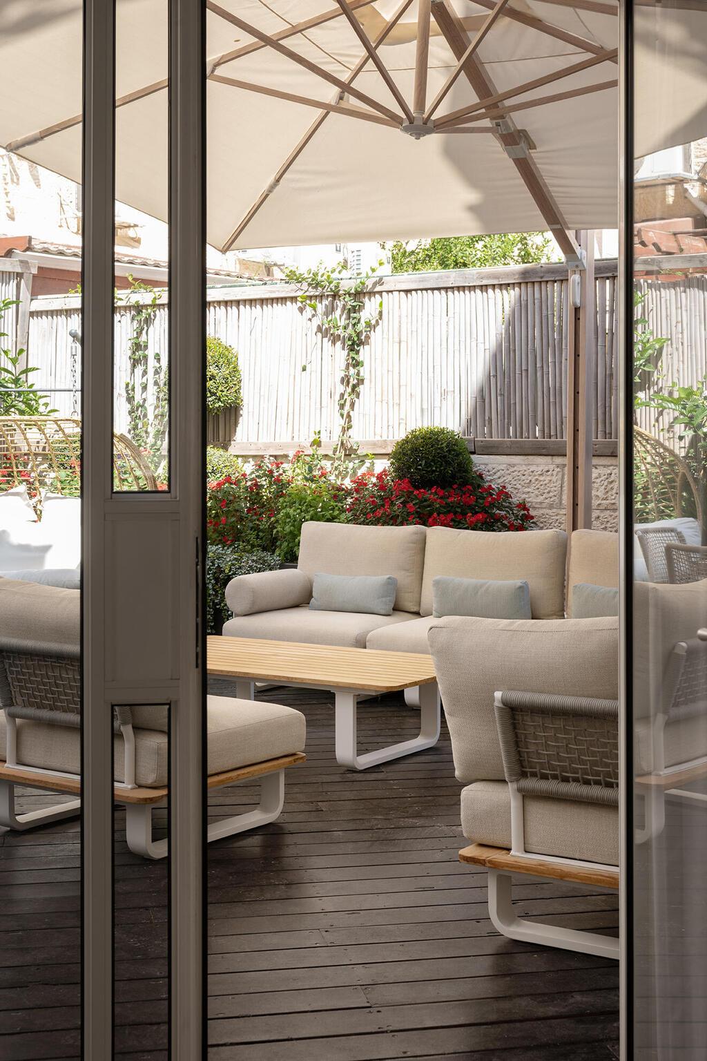 מהוויטרינה הגדולה יש יציאה לחצר וגם בה שפע פינות ישיבה (צילום: גדעון לוין) בית פרטי בירושלים, עיצוב: קרן אטלס דרור