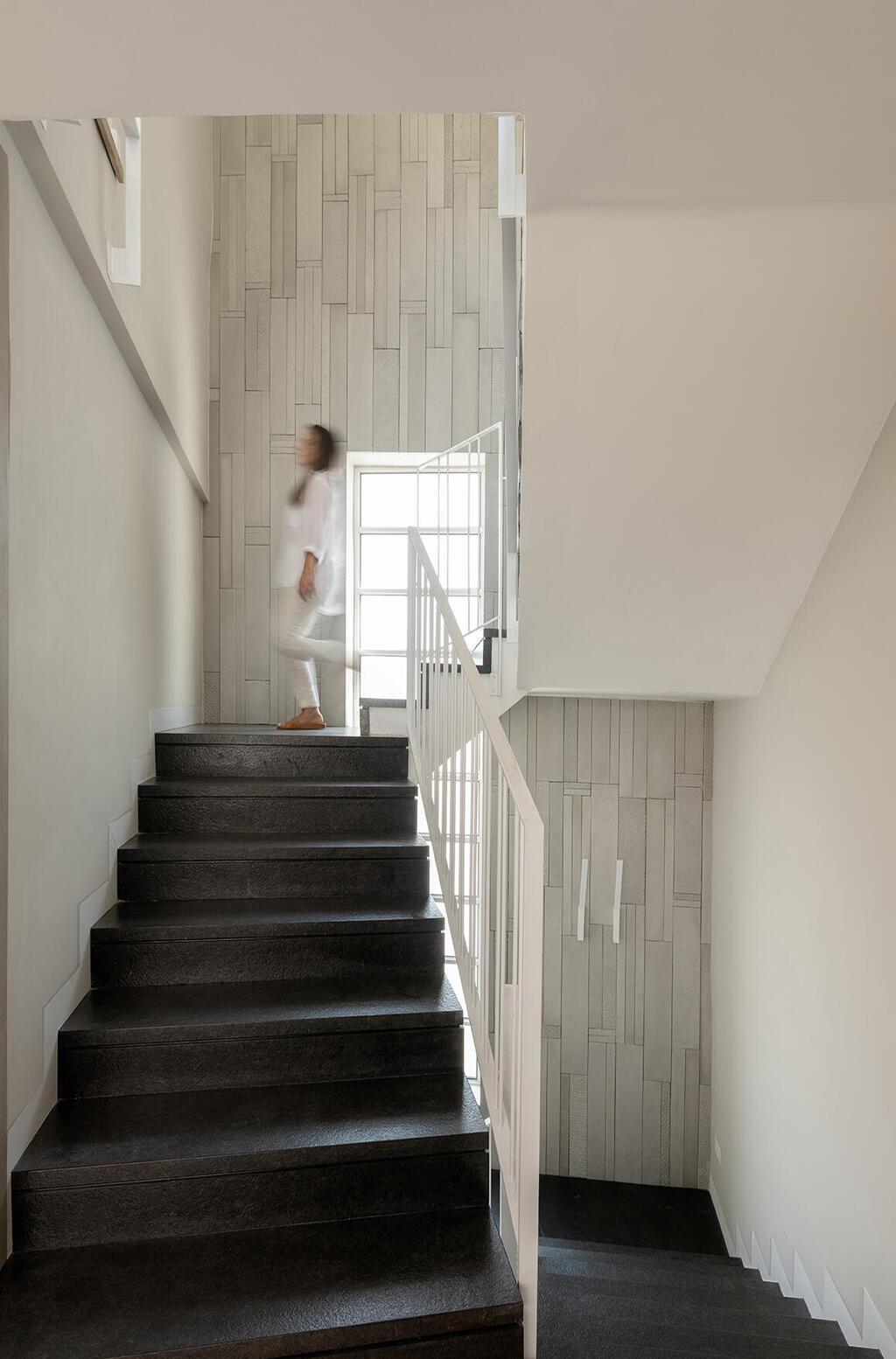 מדרגות כהות ומעקה בהיר מובילים למטה למרתף ולמעלה לחדרי השינה (צילום: גדעון לוין) בית פרטי בירושלים, עיצוב: קרן אטלס דרור
