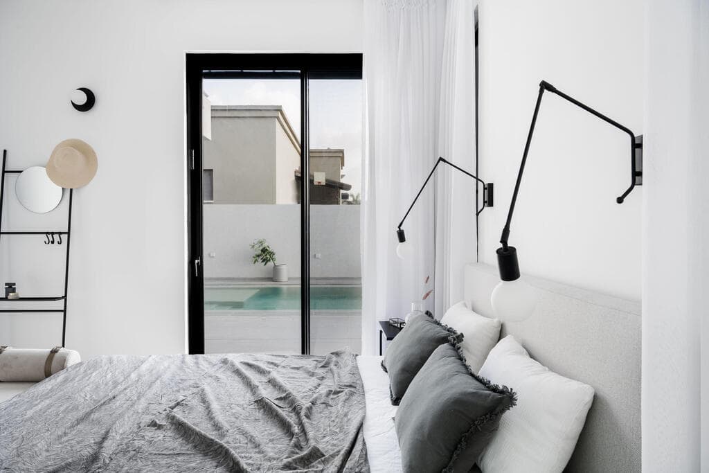 גם חדר השינה של הסבים בהיר ברובו - ומשקיף לבריכה (צילום: קרין רבנה) הבית השכן, של ההורים. עיצוב: ליאת שעיה