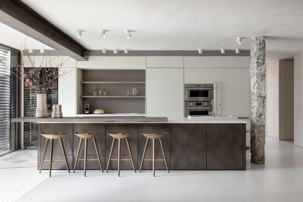 במקביל לארונות ניצב אי גדול מחופה במתכת בגוון נחושתי (צילום: איתי בנית) בית בתכנון האדריכלית איילת פרי שרון