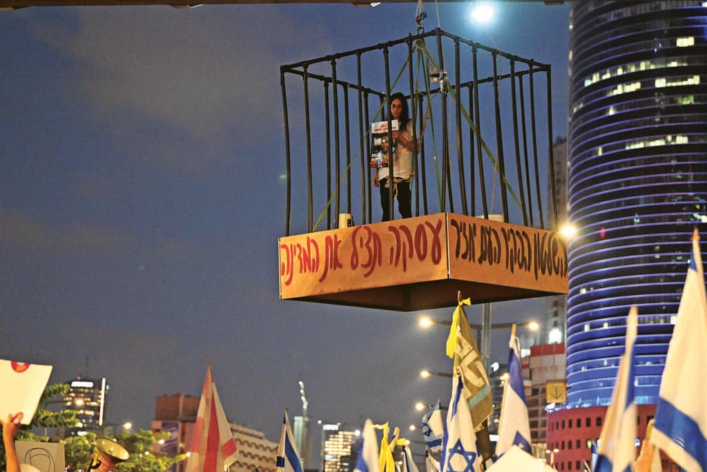 עינב צנגאוקר בכלוב, מפגינים מריעים לה (צילום: יובל חן) עינב צנגאוקר בכלוב, מפגינים מריעים לה