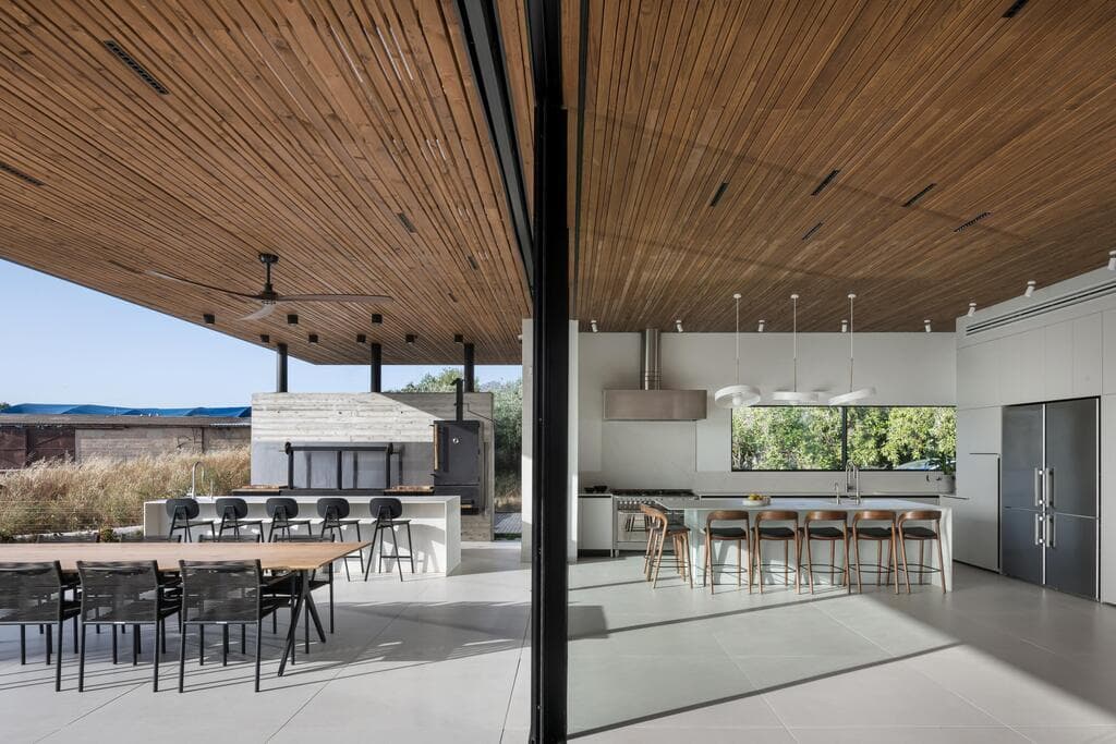 מטבח מקצועי בפנים ומטבח מקצועי בחוץ. מעל שניהם - תקרת עץ (צילום: עמית גושר) בית לשף במושב, תכנון: רון שינקין