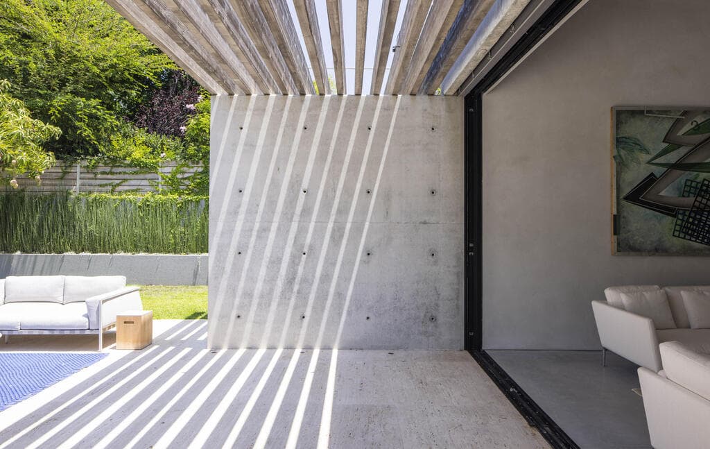 היציאה מהסלון לחצר, מוצלת בחלקה (צילום: נמרוד לוי) בית פרטי בהרצליה פיתוח, תכנון: עמיר צורף
