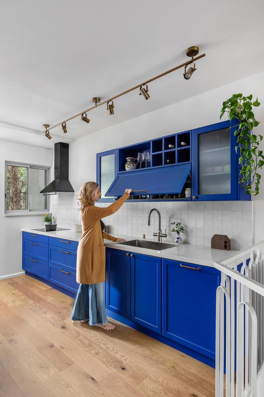 עבור המטבח נבחר כחול עמוק. בולט במיוחד על רקע הפרקט והקירות הלבנים (צילום: שירן כרמל) דירת הקשתות, מעוז אביב, עיצוב: מיה חכמו גולדברג ורונית חלג