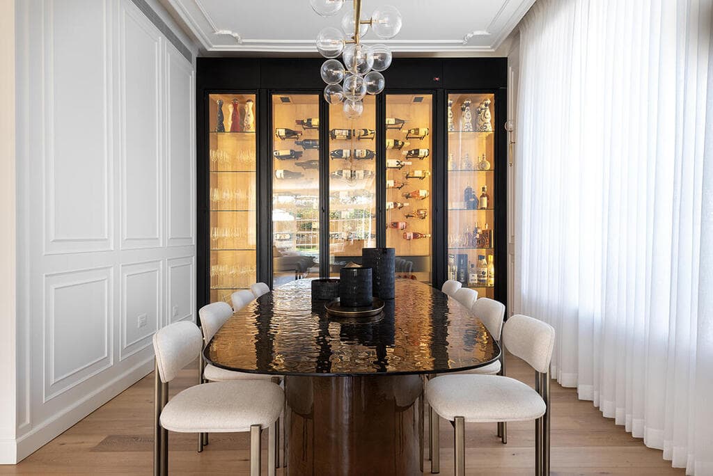 פינת האוכל מאופיינת בתקרה מעוטרת ובקרניזים עדינים - וגם בקיר יין מואר ומעוצב (צילום: שי אדם) בית בסגנון טוסקנה בשרון, אדריכלות ועיצוב פנים: שירלי דן