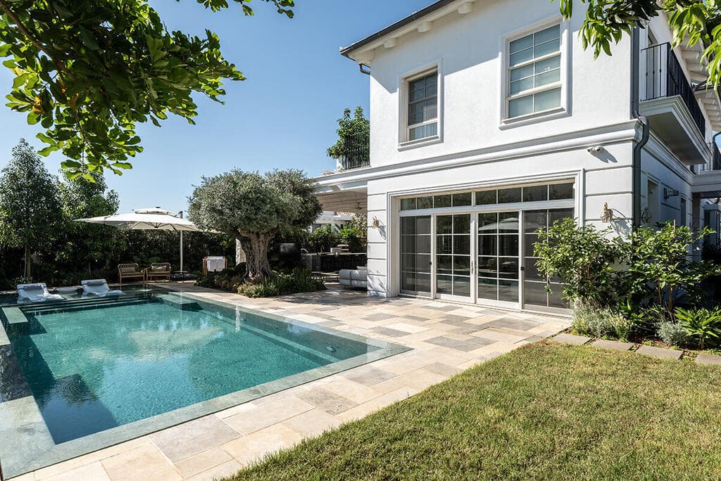 שתי הצלעות של הבית נפתחות זו אל זו ומחבקות את החצר (צילום: שי אדם) בית בסגנון טוסקנה בשרון, אדריכלות ועיצוב פנים: שירלי דן