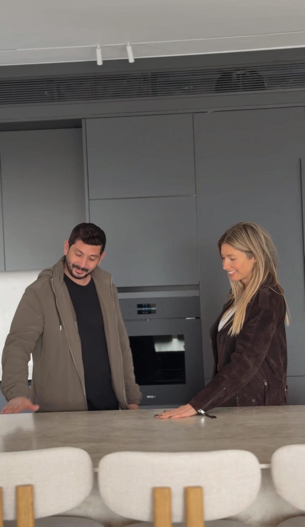 מטבח אפור ומולו אי בהיר עם סיכאות מרופדים. הימלבלוי ואביתר רפאל דהן המעצב (צילום: ירדן גלולה) הדירה החדשה של עדי הימלבלוי