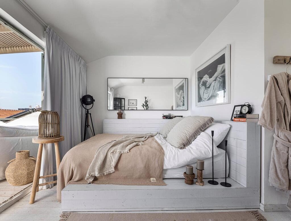 המיטה על במת עץ ויש יציאה למרפסת (צילום: גדי יוסף) בית בנווה צדק, עיצוב: נעמה רודין אשר