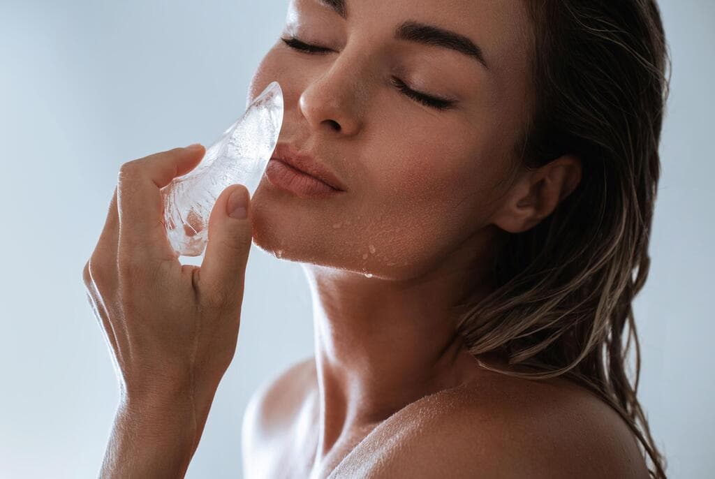 אשה מחזיקה קרח