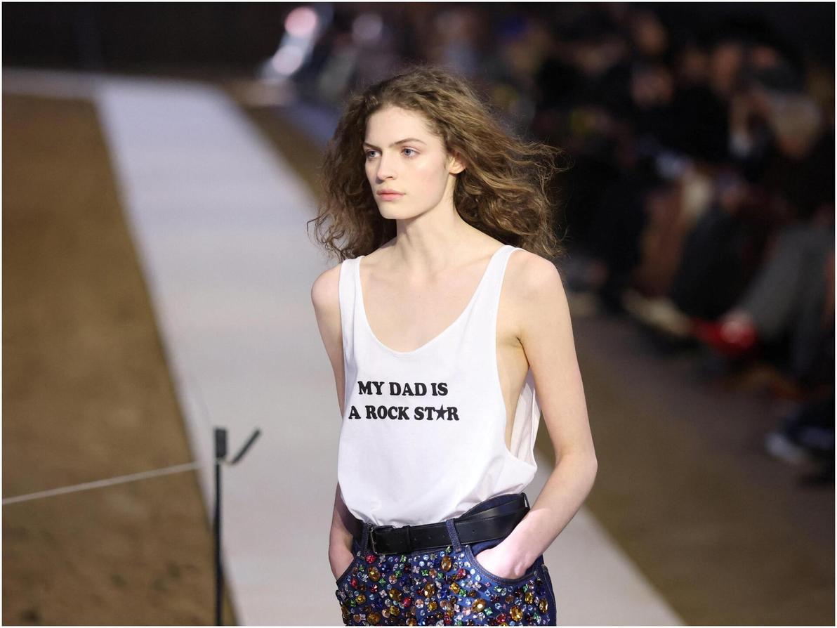 אחת התמונות הוויראליות מהתצוגה הייתה גופייה עם הכיתוב "אבא שלי כוכב רוק", בעוד אביה פול עודד מהשורה הראשונה (צילום: REUTERS/Stephane Mahe) סטלה מקרטני, תצוגת סתיו-חורף 2026-27 בשבוע האופנה בפריז