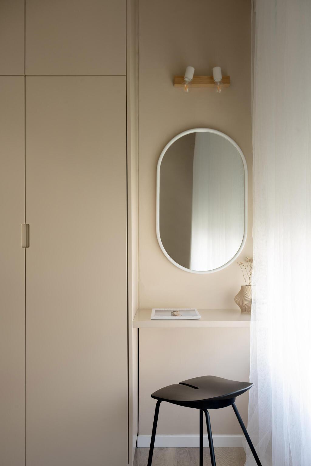שולחן איפור מינימלסטי שובץ בהמשך לארון, ליד חלון עם אור טבעי (צילום: גדעון לוין) שיפוץ דירה ישנה, עיצוב: שרון קנת