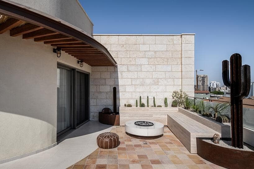 ספסל בנוי, גינת קקטוסים ואלמנטים פיסוליים מקורטן לצד שולחן אש לקומזיצים (צילום: תמיר רוגובסקי) דירת רווק ביפו, עיצוב: ארז עזרא