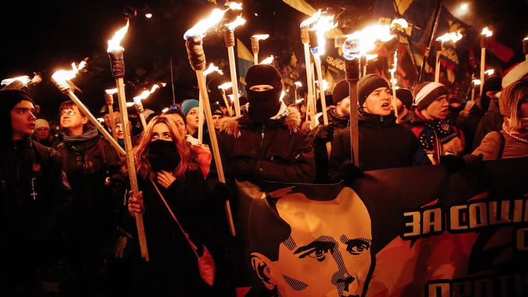 אוקראינים עם כרזה ותמונתו של סטפן בנדרה, ב-2015. "האדרת הנאציזם"