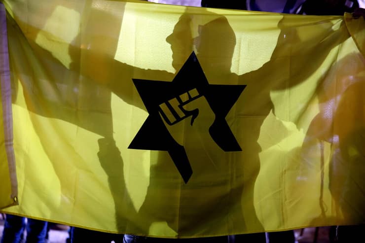 פעייל ימין עם דגל תנועת "כך" בהפגנה בירושלים, ב-2015
