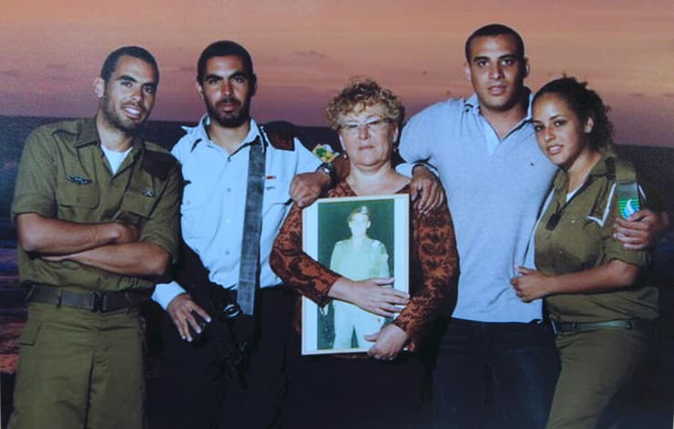 מרים פרץ מחזיקה תמונה של בנה הבכור אוריאל ז"ל, לפני שבנה השני אלירז נהרג
