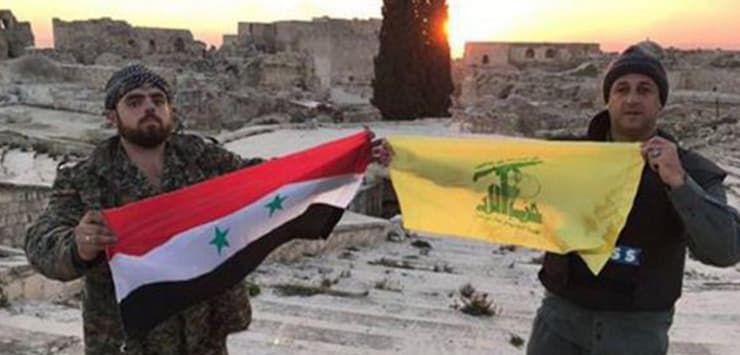 דגל חיזבאללה לצד דגל סוריה בחלב. ארכון הטרור צבר ניסיון קרבי ושיפר יכולות מודיעיניות ומבצעיות