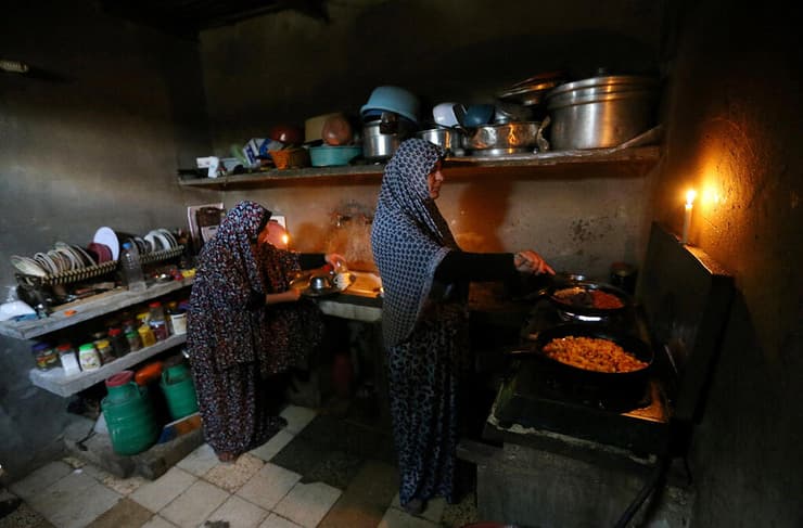 ארכיון. נשים פלסטיניות מבשלות בזמן הפסקת חשמל בעזה