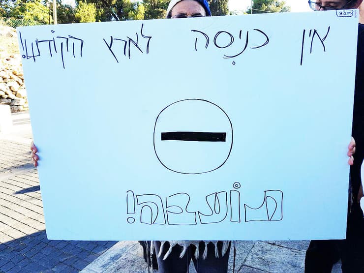 אדם מחזיק שלט במחאה נגד מצעד הגאווה, ארכיון
