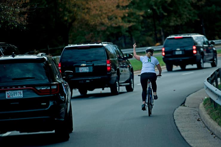 ג'ולי בריקסמן רוכבת אופניים אצבע משולשת לשיירה של דונלד טראמפ