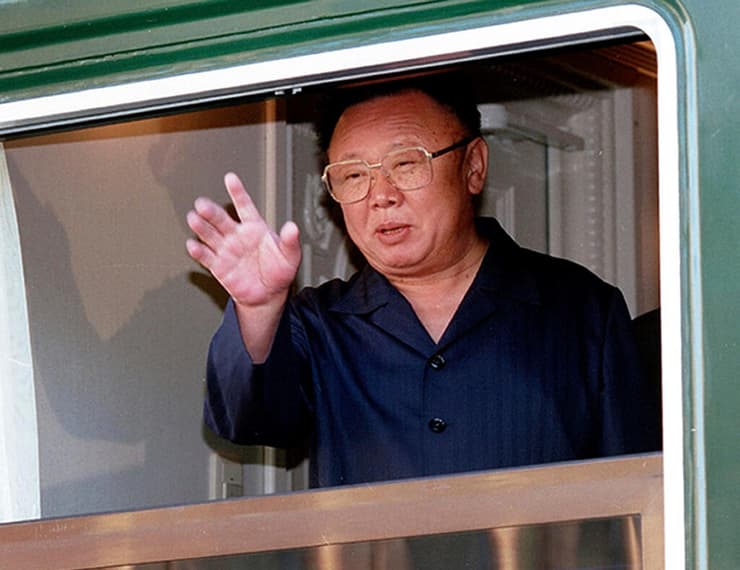 שליט צפון קוריאה קים ג'ונג איל מנופף בידיו מתוך רכבת 20 באוגוסט 2002